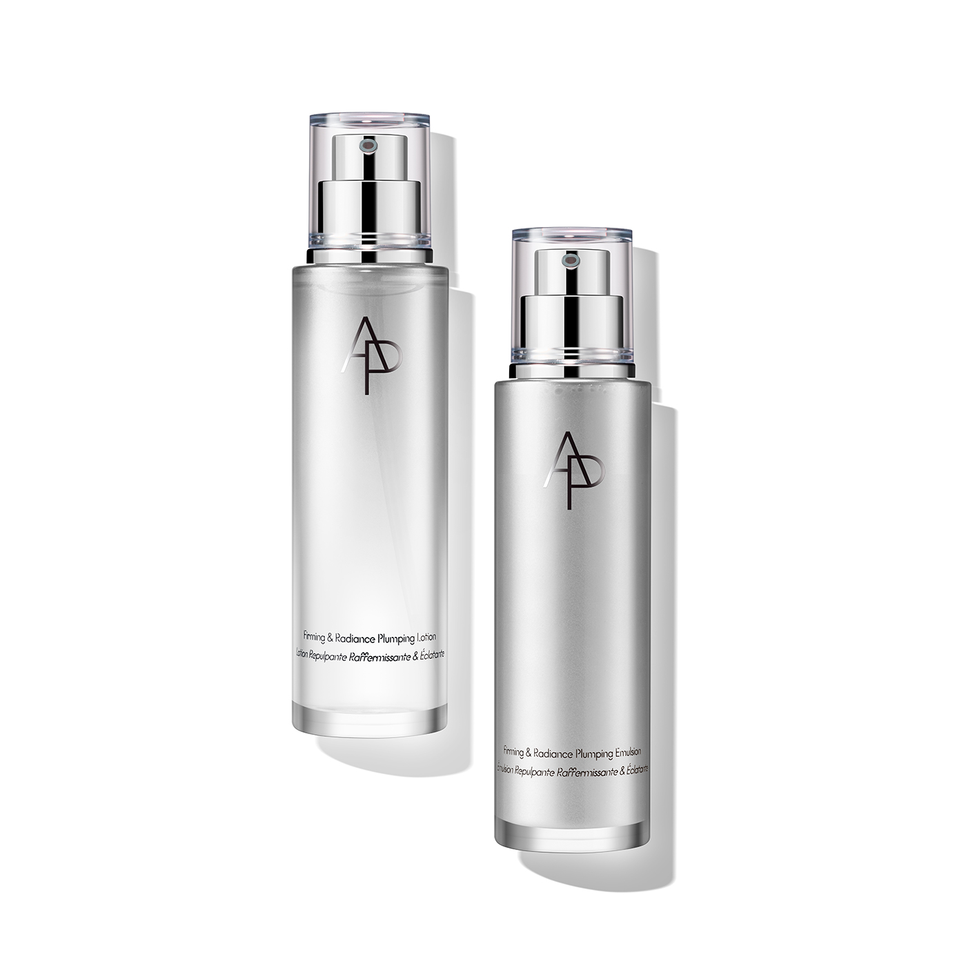 은은한 광택의 실버 용기에 담긴 M.D. 퍼밍 앤 래디언스 플럼핑 에멀전 두 개가 나란히 놓여 있으며, 제품의 고급스러움과 피부 탄력 및 광채 개선 효과를 시각적으로 보여줍니다.